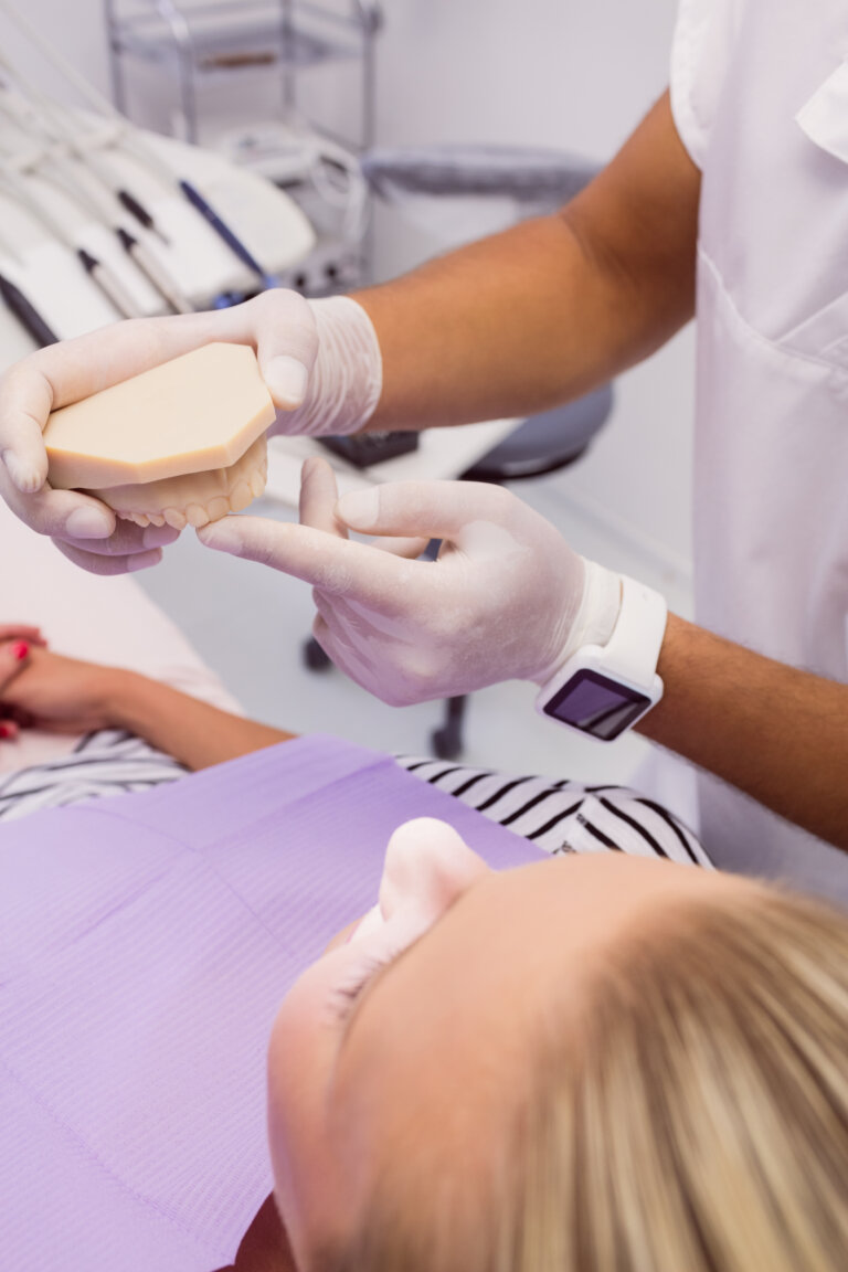 Dentist showing denture model to the patient in clinic